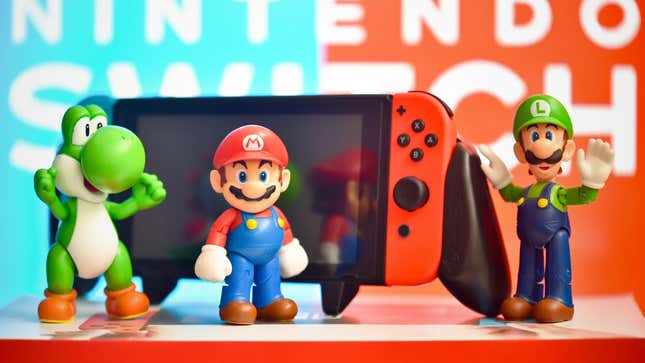 Mario, Luigi, and Yoshi stand in front of a Switch.