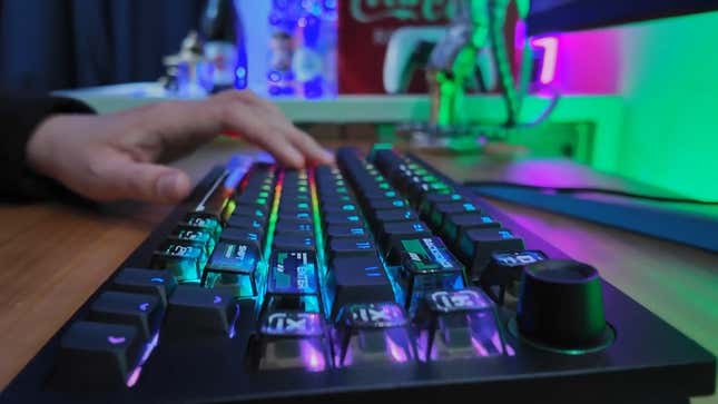 A hand presses keys on a keyboard.
